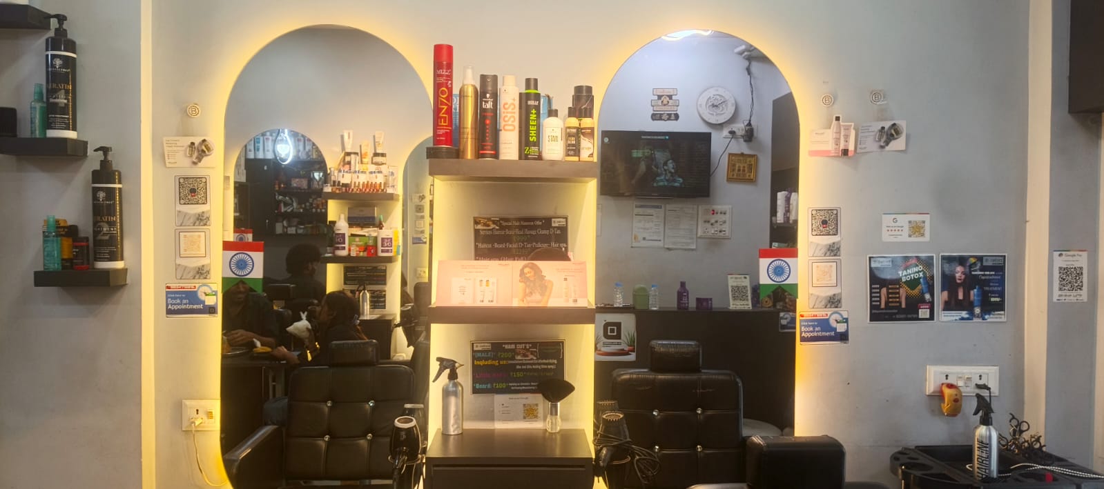 Wide view of D Squared Unisex Salon styling stations with arched backlit mirrors