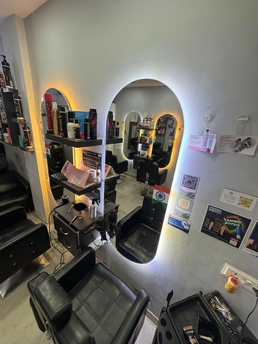 Interior view of D Squared Unisex Salon with backlit mirror arches and styling chairs